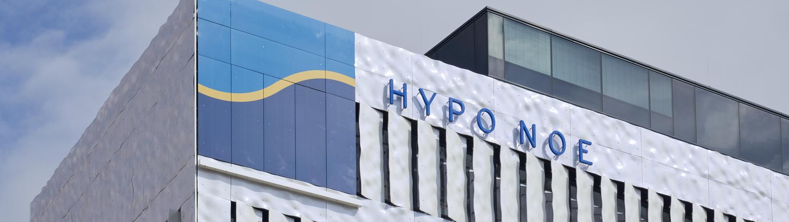 close-up of a white bureau building with blue-yellow logo of HYPO NOE